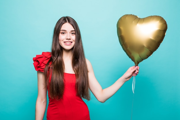 Schöne junge Frau im roten Kleid mit Herzform-Luftballon. Frau am Valentinstag. Symbol der Liebe