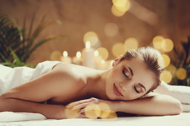 Schöne junge Frau liegend und wartend auf ihre Massage. Spa-Konzept
