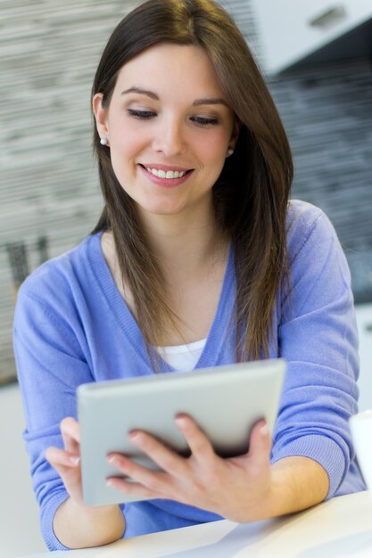 Schöne junge Frau mit digitaler Tablette