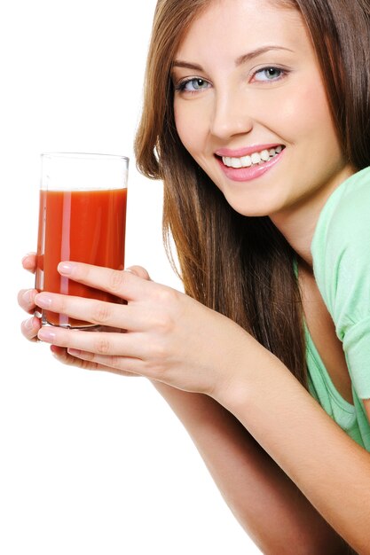 Schöne junge Frau mit einem Glas Tomatensaft auf Weiß