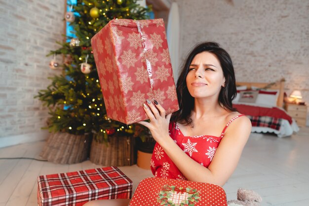 Schöne junge Frau mit Geschenken auf dem Weihnachtsbaum