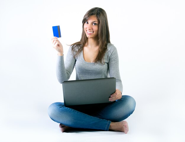 Schöne junge Frau mit Laptop im Studio