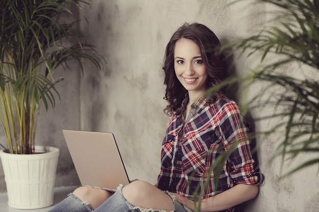 Schöne junge Frau mit Laptop