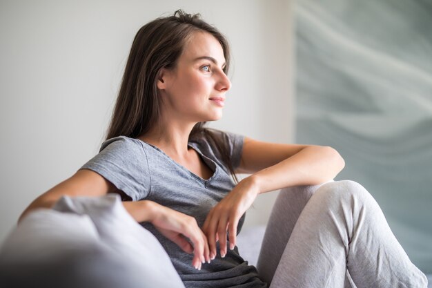 Schöne junge Frau mit weißem perfektem Lächeln zu Hause