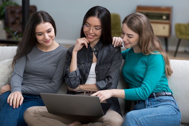 Schöne junge Frauen, die einen Laptop durchsuchen