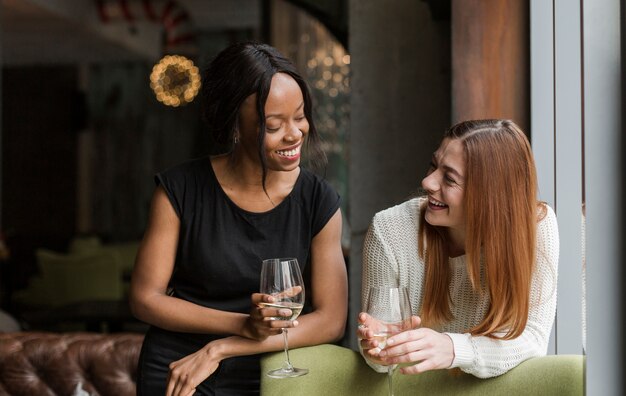 Schöne junge Frauen, die Wein zusammen haben