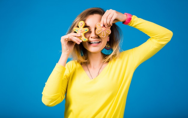 Schöne junge Hipsterfrau, die Kekse isst