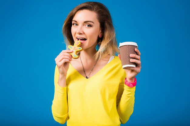 Schöne junge Hipsterfrau, die Kekse isst