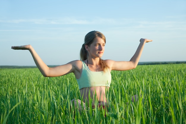 Schöne junge Mädchen üben Yoga gegen blauen Himmel