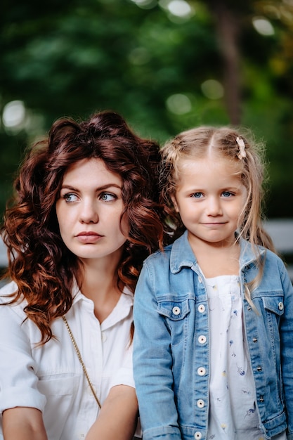 Schöne junge Mutter und Tochter im sonnigen Tag, glückliche Familie