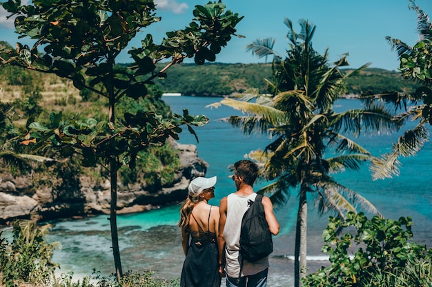 Schöne junge paare, die auf der see- und strandliebe und -empfindlichkeit aufwerfen