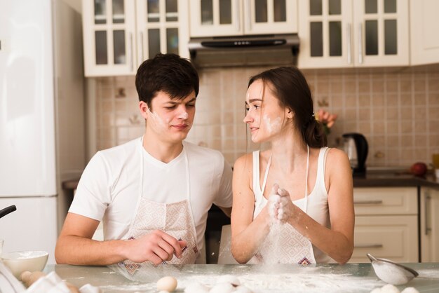 Schöne junge Paare, die zusammen kochen