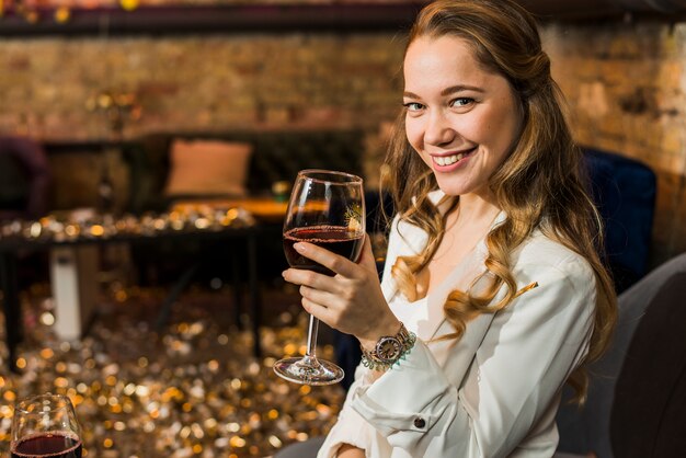 Schöne lächelnde Frau mit Glas Wein