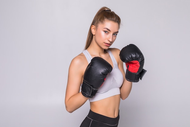 Schöne lächelnde junge Fitnessfrau trägt Boxhandschuhe