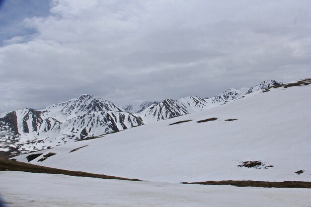 Schöne Landschaft der hohen felsigen Berge bedeckt mit Schnee unter einem bewölkten Himmel