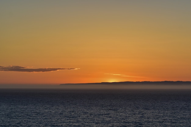 Schöne Landschaft des friedlichen Meeres mit dem atemberaubenden Sonnenuntergang im Hintergrund