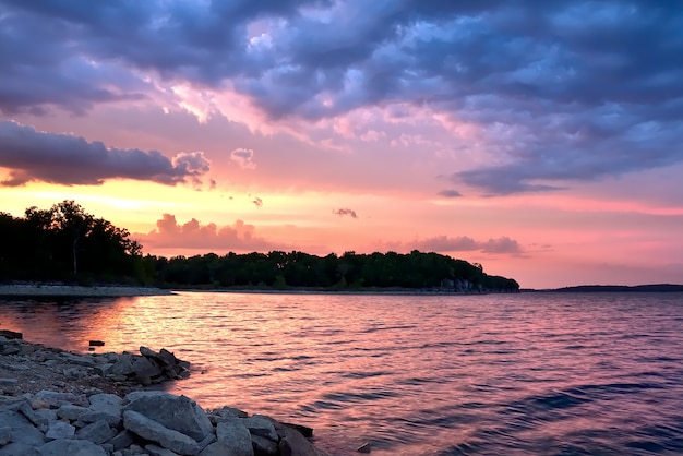 Schöne Landschaft des Sonnenuntergangs, der sich im Meer unter den atemberaubenden bunten Wolken spiegelt