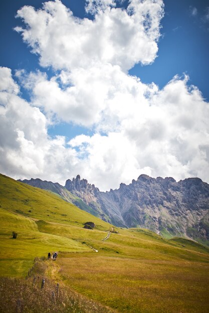 Schöne Landschaft einer grünen Landschaft mit hohen felsigen Klippen unter weißen Wolken in Italien