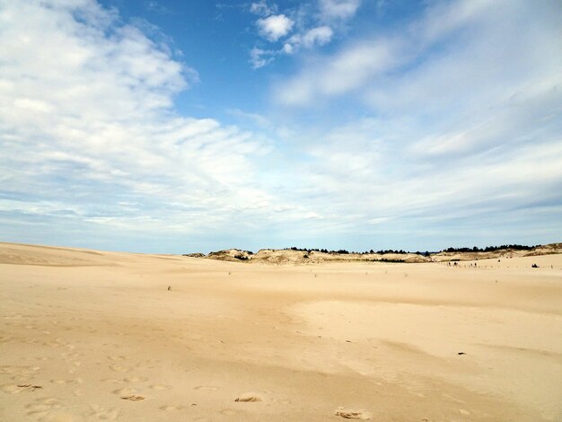 Schöne Landschaft eines Sandstrandes unter einem bewölkten Himmel in Leba, Polen