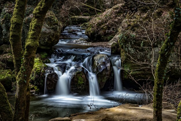 Schöne Landschaft eines Wasserfalls im Wald, umgeben von Felsformationen