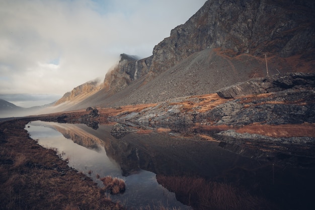 Schöne Landschaft mit felsigen Klippen spiegelt sich in einem sauberen Bach in Island