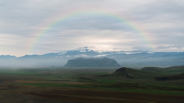 Kostenloses Foto schöne landschaft mit regenbogen und bergen