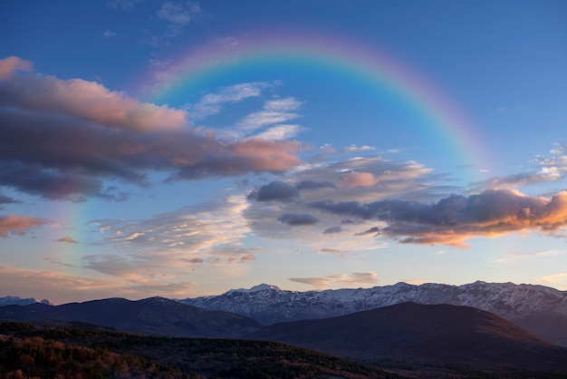 Kostenloses Foto schöne landschaft mit regenbogen und wolken