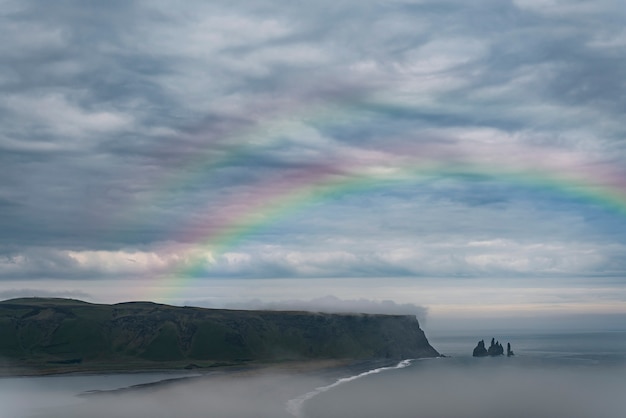 Schöne Landschaft mit Regenbogen und Wolken