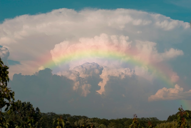 Kostenloses Foto schöne landschaft mit regenbogen und wolken