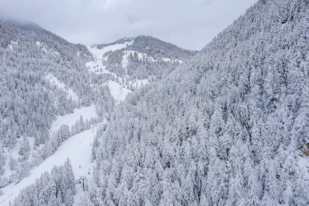 Schöne Luftaufnahme eines Skigebiets und eines Dorfes in einer Berglandschaft in den Alpen
