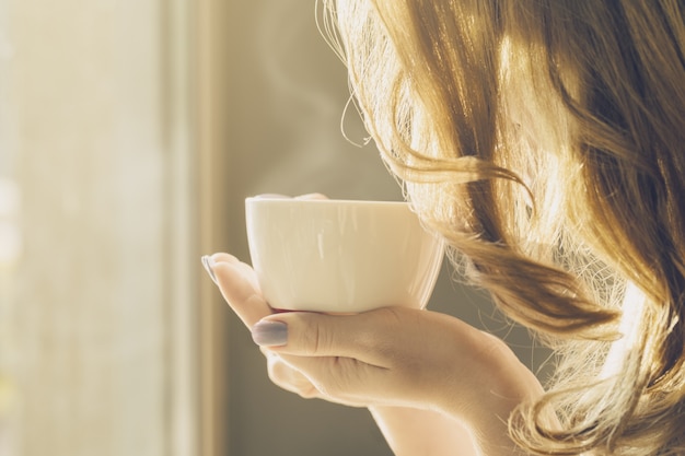 Kostenloses Foto schöne mädchen junge frau trinkt kaffee allein im café
