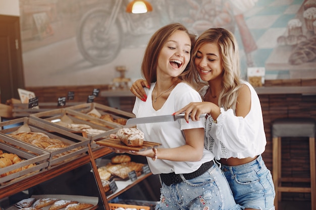 Schöne Mädchen kaufen Brötchen in der Bäckerei