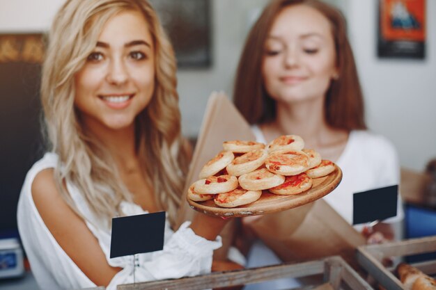 Schöne Mädchen kaufen Brötchen in der Bäckerei