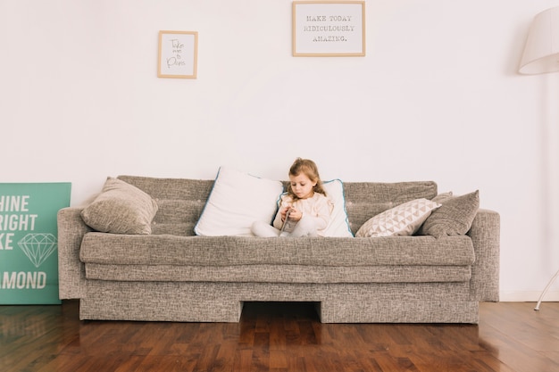 Schöne Mädchen lesen auf dem Sofa