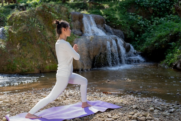 Schöne Mädchen spielen Yoga im Park