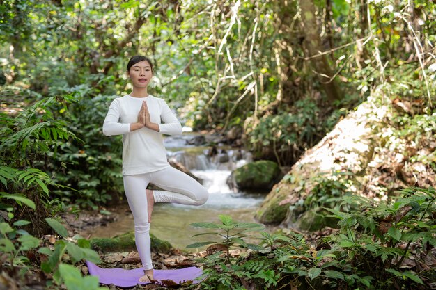 Schöne Mädchen spielen Yoga im Park