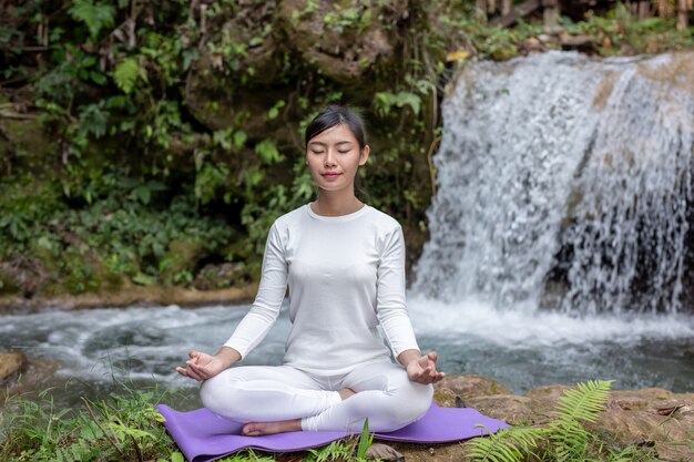 Schöne Mädchen spielen Yoga im Park