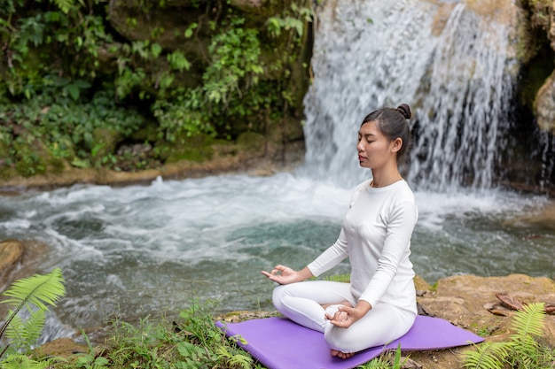 Schöne Mädchen spielen Yoga im Park