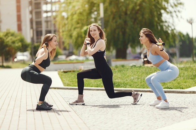 Schöne Mädchen trainieren. Sportmädchen in einer Sportbekleidung. Frauen am Wasser.