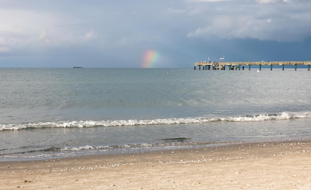 Kostenloses Foto schöne meereslandschaft mit einem regenbogen während des regens