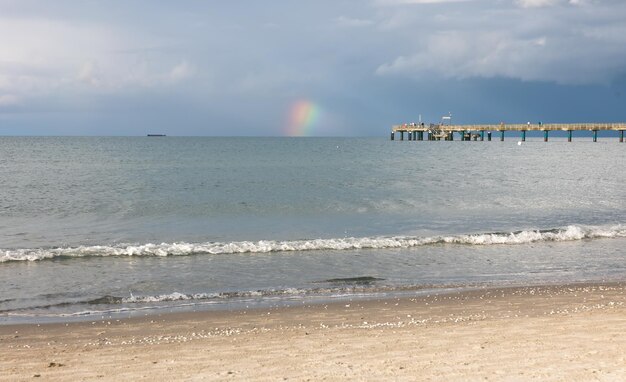Schöne Meereslandschaft mit einem Regenbogen während des Regens
