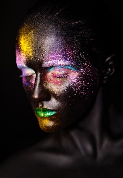 schöne Modellfrau mit kreativem Kunststoff ungewöhnliche schwarze Maske helles buntes Make-up mit schwarzem Gesicht
