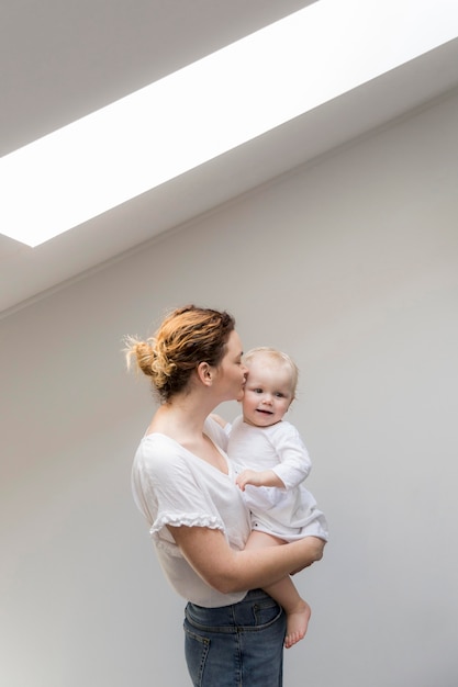 Kostenloses Foto schöne mutter, die baby küsst