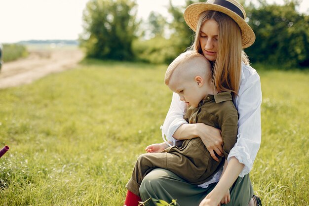 Schöne Mutter mit kleinem Sohn auf einem Sommergebiet