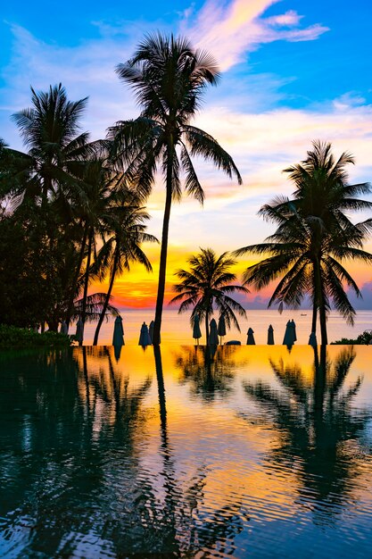 Schöne Naturlandschaft im Freien mit Seeozean- und KokosnussPalme um Swimmingpool bei sunrsie oder Sonnenuntergang