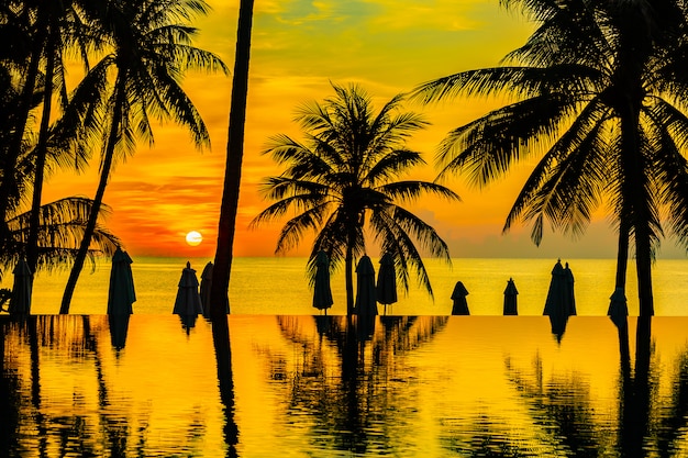 Schöne Naturlandschaft im Freien mit Seeozean- und KokosnussPalme um Swimmingpool bei sunrsie oder Sonnenuntergang