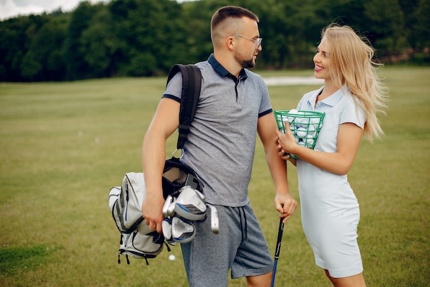 Schöne Paare, die Golf auf einem Golfplatz spielen