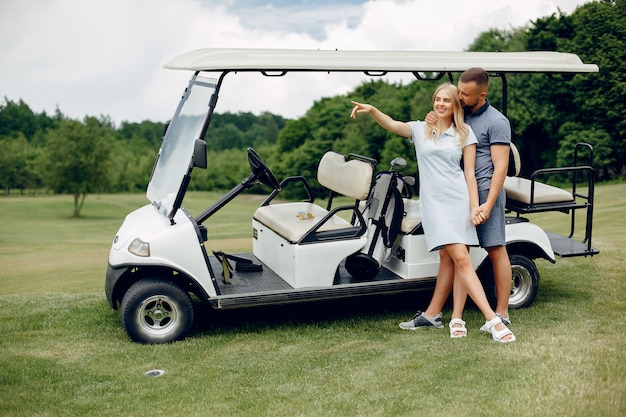 Schöne Paare, die Golf auf einem Golfplatz spielen