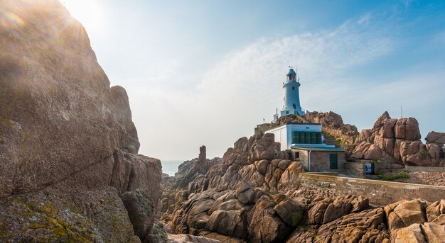 Schöne Panoramaaufnahme von Klippen mit einem Leuchtturm und einem ruhigen Meer