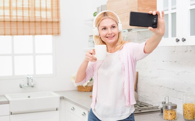 Schöne reife Frau, die zu Hause ein selfie nimmt